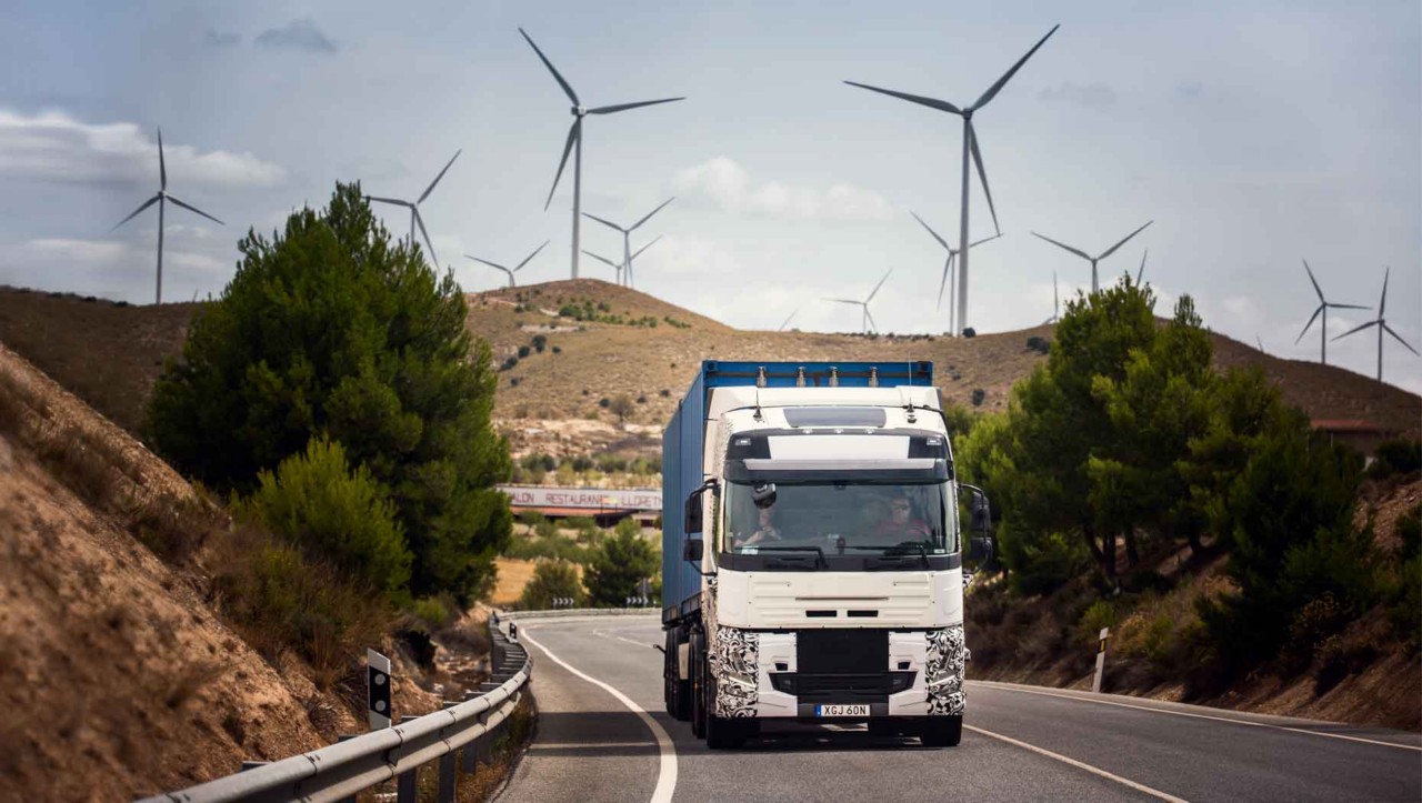 A test truck on the road in Spain with wind turbines in the background